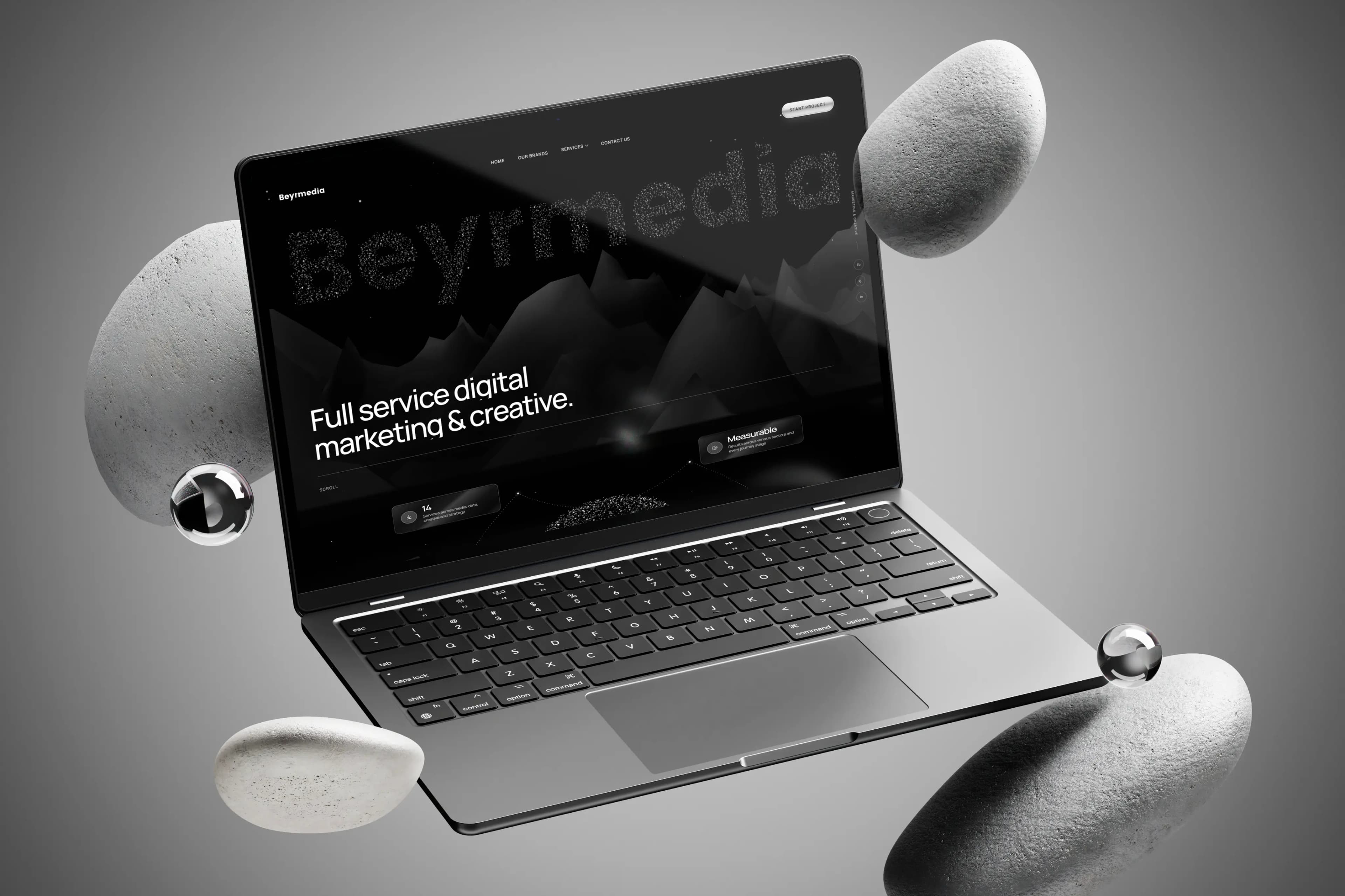 Beyrmedia website displayed on a laptop with floating stones